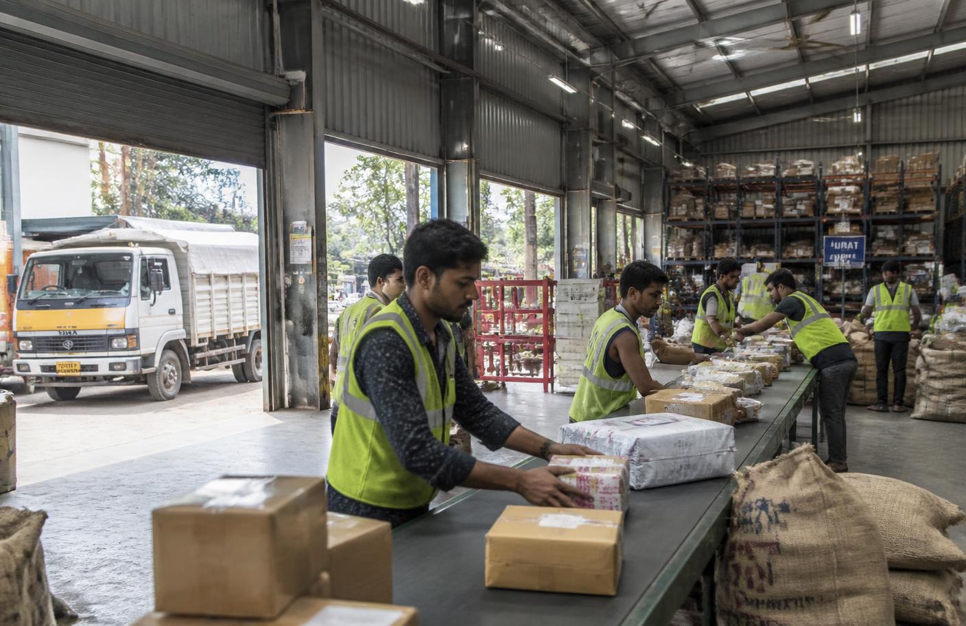Workers sorting parcels inside an Indian Nettaa Logistics warehouse hub